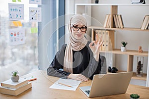 Woman posing behind computer on working day in office