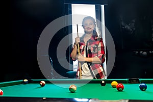 Woman posing with cue in billiard pub