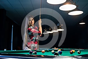 Woman posing with cue in billiard pub