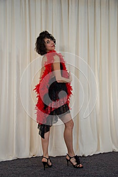 Woman posing with dancing costume, with red feather boa