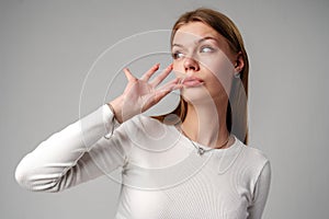 Woman Posing With Finger on Lips Hush Sign in Studio photo