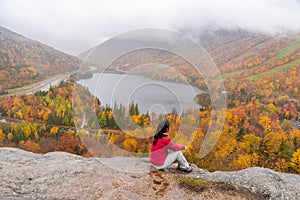 Woman posing in front of beautiful Echo Lake from Artists Bluff Loop in New Hampshire USA