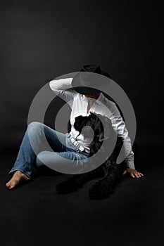 Woman is posing with her dog sitting on the floor