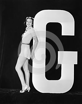 Woman posing with huge letter G photo