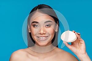 Woman posing isolated over blue wall holding soap