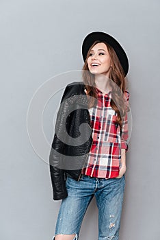 Woman posing with leather jacket over shoulder and looking away