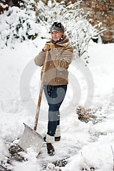 Woman posing with snow shovel