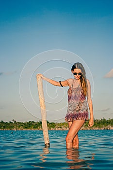 Woman posing with sunglasses in the lagoon, Laguna Bacalar, Chetumal, Quintana Roo, Mexico.
