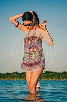 Woman posing with sunglasses in the lagoon, Laguna Bacalar, Chetumal, Quintana Roo, Mexico.