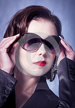 woman posing with sunglasses, red lipstick and a jacket