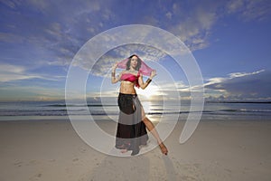 Woman posing with a veil at sunrise