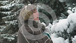 Woman is posing in winter forest, beautiful landscape with snowy fir trees