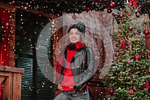 Woman posing in the wooden terrace with Christmas background under the snowing.