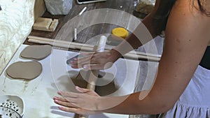 Woman potter preparing and rolling clay with a rollingpin