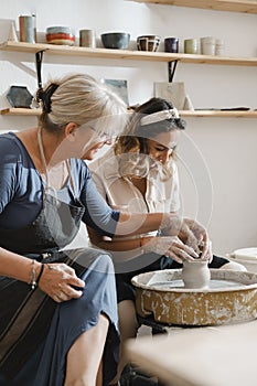 Woman at pottery workshop learning to make bowls from clay