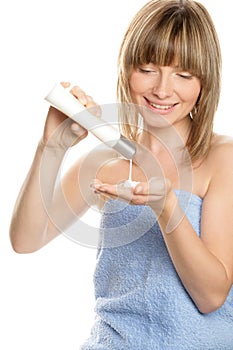 Woman pouring body lotion in hand