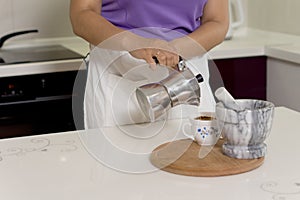 Woman pouring coffee from a percolator