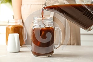 Woman pouring cold brew coffee into mason jar