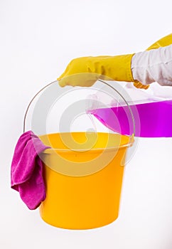 Woman pouring detergent into bucket on white background