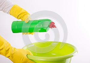 Woman pouring detergent into washbasin on white background