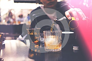 Woman pouring drink from a bottle to glass