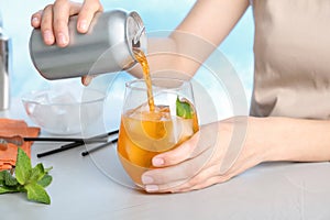 Woman pouring drink from tin can into glass