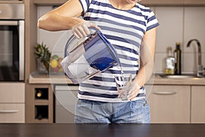 Woman pouring filtered water into a glass
