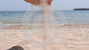 Woman Pouring Fine Sand Through Fingers