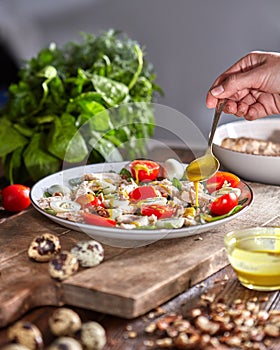 Woman pouring freshly cooked salad mustard sauce on a wooden board. Natural organic dieting food.