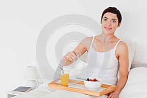 Woman pouring milk into her cereal