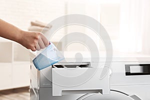 Woman pouring powder into drawer of washing machine indoors, closeup with space for text.