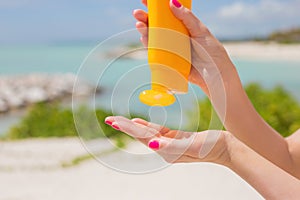 Woman pouring sunscreen in hand