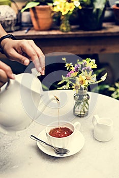 Woman pouring tea in a cup