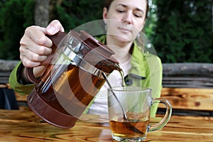 Woman pouring tea into glass