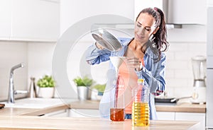 Woman pouring used cooking oil for recycling and reuse into the plastic bottle to be made in the factory into the fuel additive