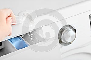 Woman pouring washing detergent into the washing machine tray. housekeeping and householding.