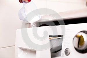 Woman pouring washing powder into the washing machine