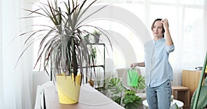 Woman pouring water in houseplants