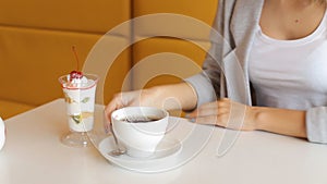 Woman pours hot water from the kettle into the cup