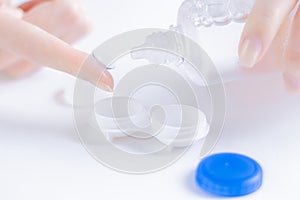 Woman pours liquid on a lens for the eyes. Ophthalmology concept