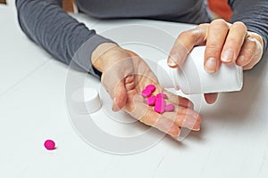 Woman pours out medicine into her hand