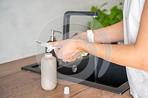 A woman pours soap or detergent from recycled packaging into a reusable bottle. Eco-friendly lifestyle concept