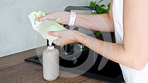 Woman pours soap or detergent from the recycled packaging into a reusable bottle. Eco-friendly lifestyle concept