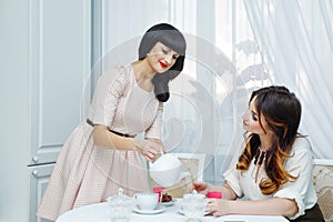 Woman pours tea girlfriend. Tea party.