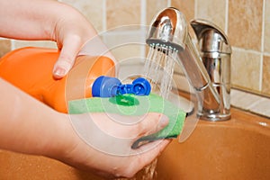 The woman pours a washing-up liquid photo