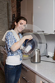 Woman pours water into the teapot from the filter