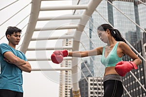 Woman practice Muay Thai punch with coach