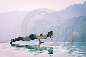 woman practice yoga on the pool above the Mountain peak