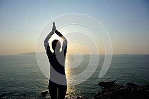 Woman practice yoga at sunrise seaside
