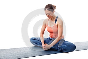 Woman practices yoga asana Baddha konasana